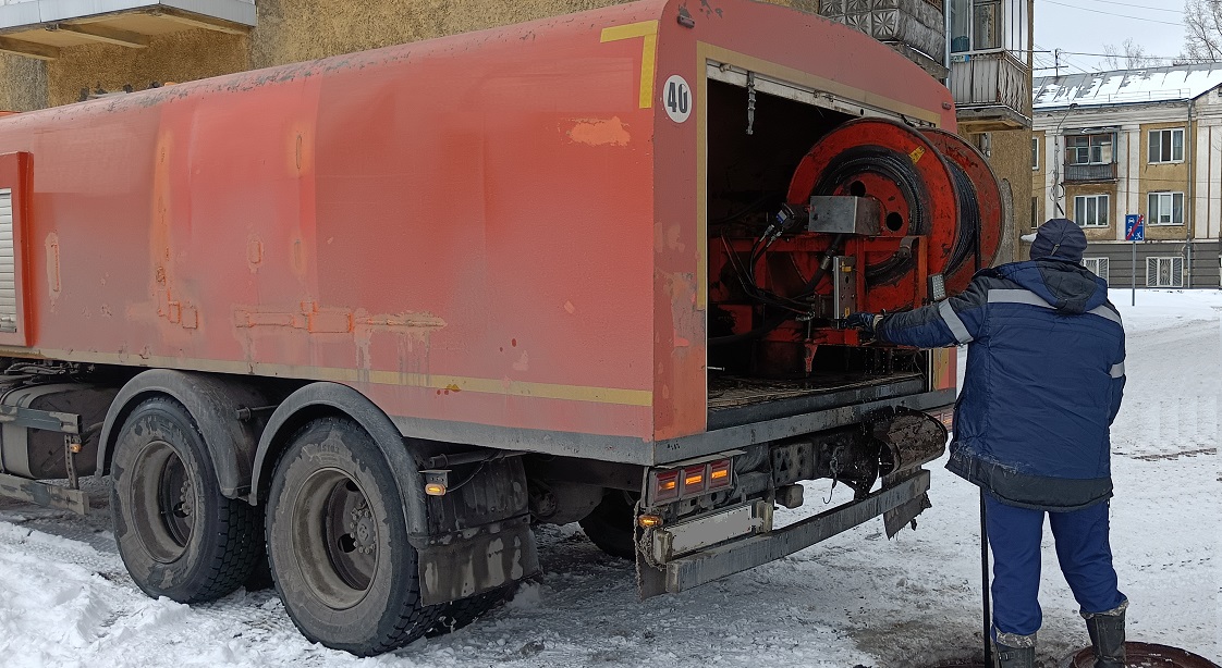 Каналопромывочная машина и работник прочищают засор в канализационной системе в Северобайкальске