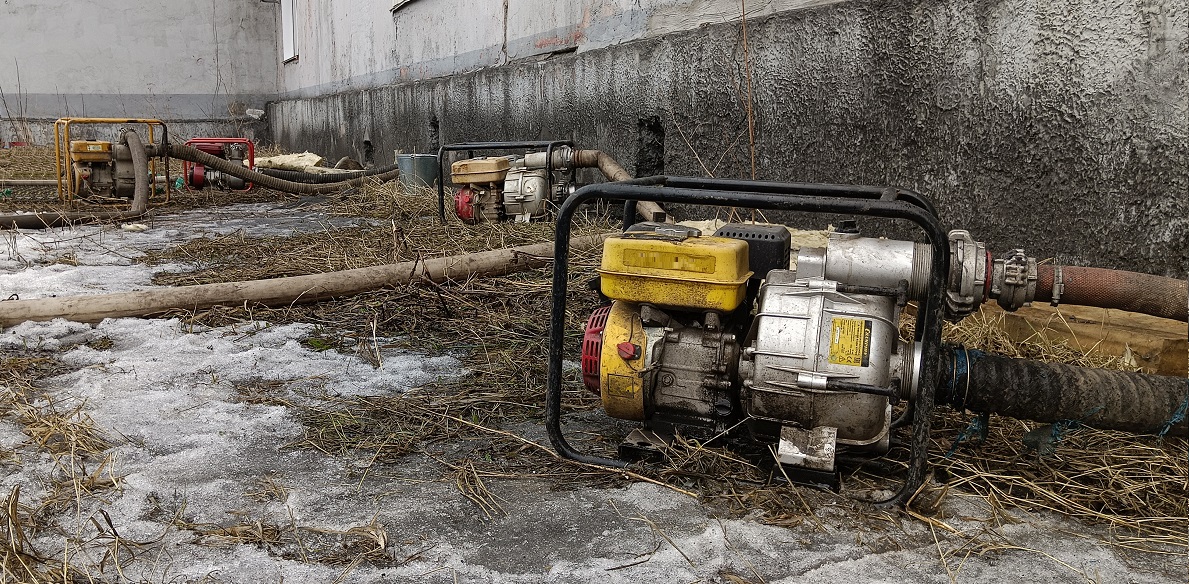 Откачка мотопомпами талой воды из подвала дома в Северобайкальске